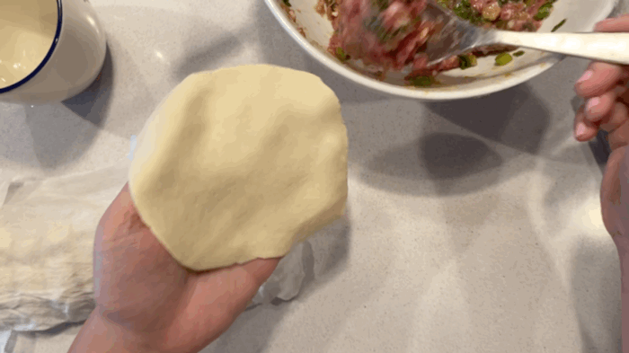 Take 1 tbsp of the meat filling and add it in the middle of the dough. 🥄